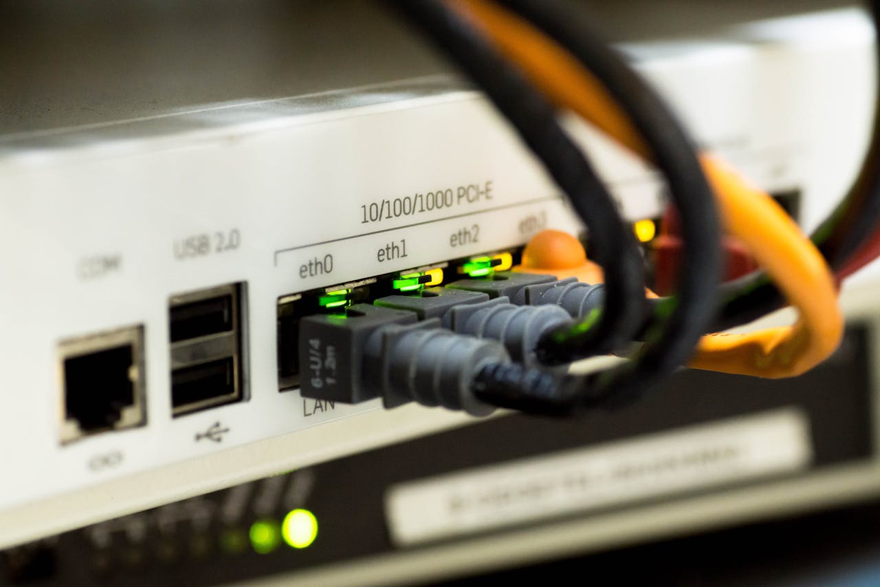 Services-03 Detailed close-up of ethernet cables and network connections on a router, showcasing modern technology.